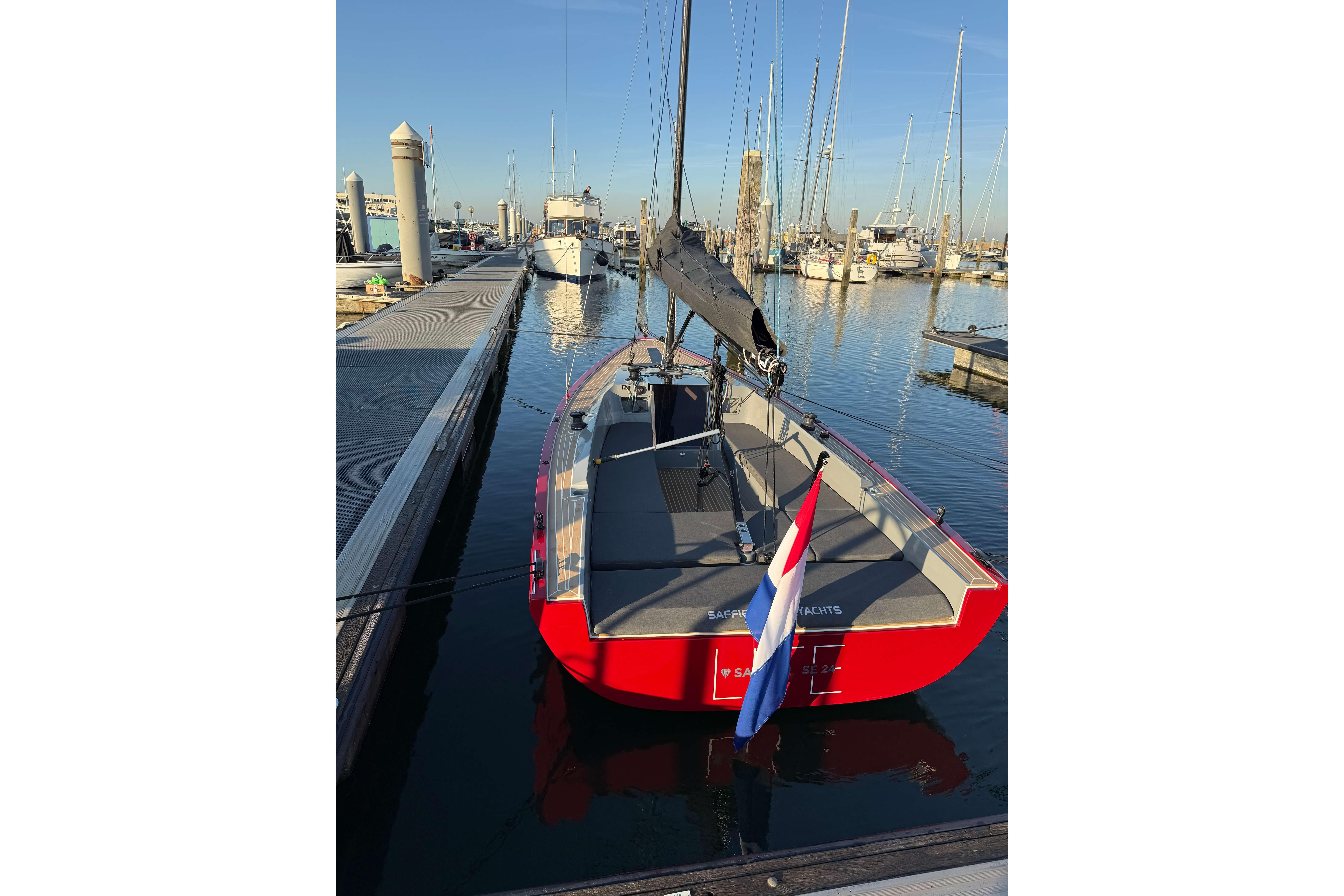 2024 Saffier SE 24 Lite sailboat docked in a marina, featuring a sleek red design.