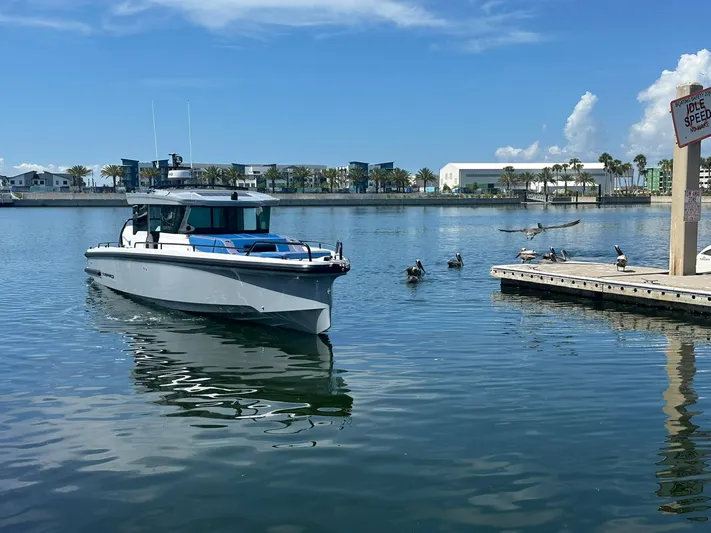 Empoleon Yacht Photos Pics 2025 Axopar 37XC CROSS CABIN BRABUS Trim boat on calm water near dock.