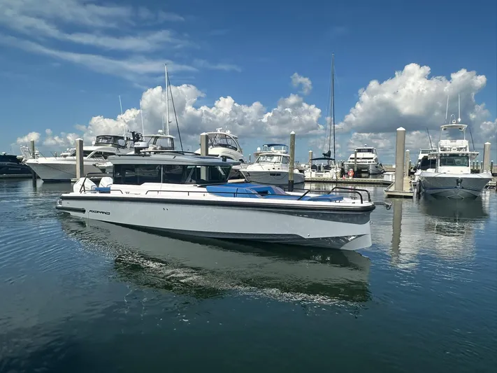 Empoleon Yacht Photos Pics 2025 Axopar 37XC CROSS CABIN BRABUS Trim boat docked in a marina under a blue sky.