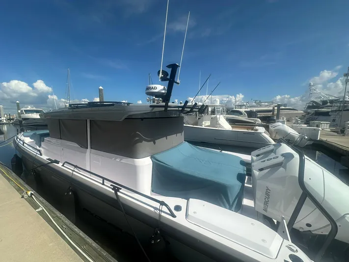 Empoleon Yacht Photos Pics 2025 Axopar 37XC CROSS CABIN BRABUS Trim docked at marina under clear blue sky.