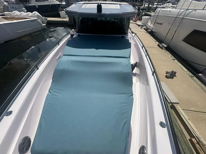 Empoleon Yacht Photos Pics 2025 Axopar 37XC CROSS CABIN BRABUS Trim boat docked, featuring a blue sunbed cover.