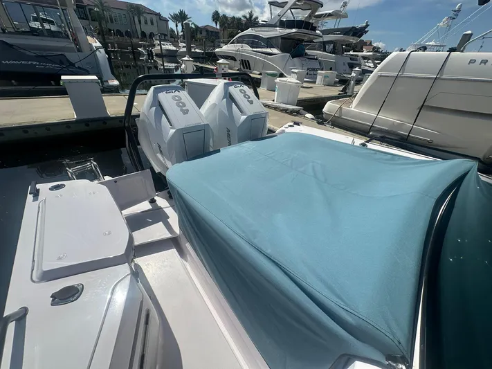 Empoleon Yacht Photos Pics 2025 Axopar 37XC CROSS CABIN BRABUS Trim docked, featuring covered seating and twin engines.