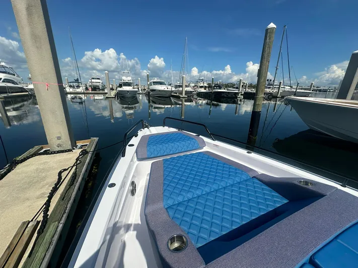 Empoleon Yacht Photos Pics 2025 Axopar 37XC CROSS CABIN BRABUS Trim docked at marina, featuring blue cushioned seating.