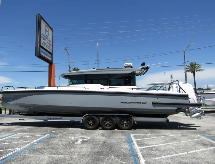 Empoleon Yacht Photos Pics 2025 Axopar 37XC CROSS CABIN BRABUS Trim boat on trailer in parking lot.