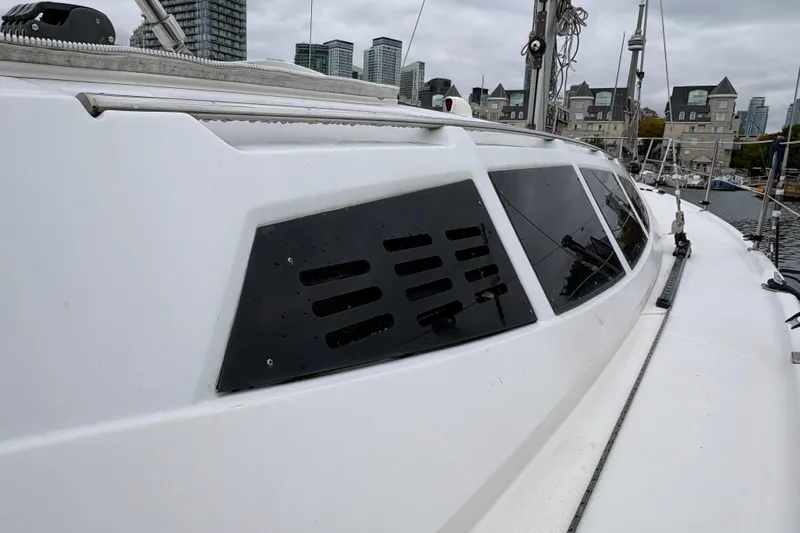 Tru Blu Yacht Photos Pics 2010 Hunter 39 sailboat with sleek windows docked in urban marina.