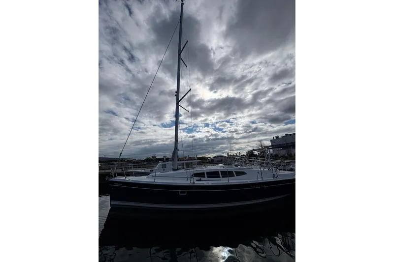 Tru Blu Yacht Photos Pics 2010 Hunter 39 sailboat docked under dramatic cloudy sky.