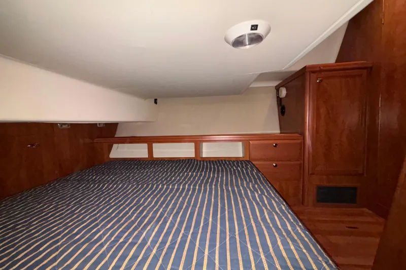 Tru Blu Yacht Photos Pics Interior cabin of 2010 Hunter 39 sailboat with wood paneling and striped bedding.