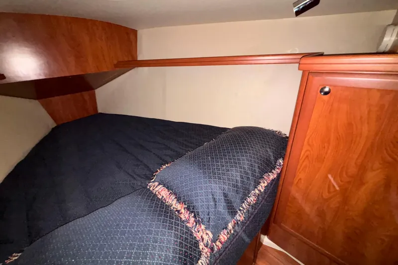 Tru Blu Yacht Photos Pics Cozy cabin interior of 2010 Hunter 39 sailboat with wooden finish and dark bedding.