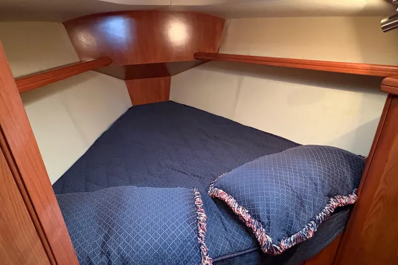 Tru Blu Yacht Photos Pics Cozy cabin interior of 2010 Hunter 39 sailboat with blue bedding and wooden accents.