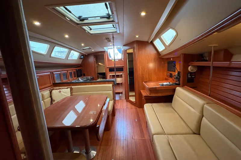 Tru Blu Yacht Photos Pics Luxurious interior of a 2010 Hunter 39 sailboat with wood finishes and seating area.