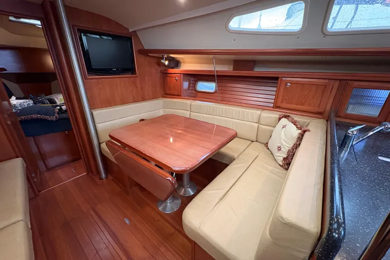 Tru Blu Yacht Photos Pics Interior of 2010 Hunter 39 sailboat with cozy dining area and wooden finishes.