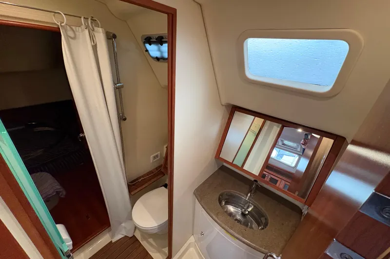 Tru Blu Yacht Photos Pics 2010 Hunter 39 yacht bathroom with sink, mirror, and porthole window.