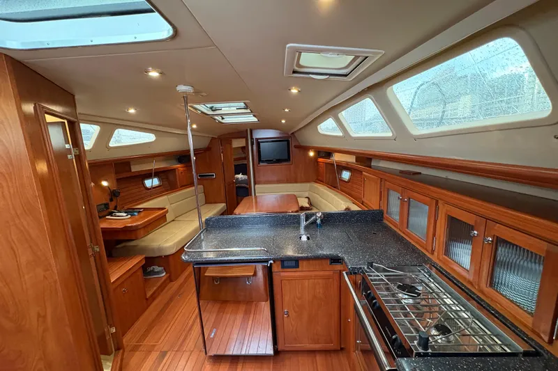 Tru Blu Yacht Photos Pics Luxurious interior of a 2010 Hunter 39 yacht with modern kitchen and seating area.