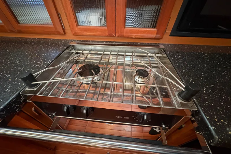 Tru Blu Yacht Photos Pics Stainless steel stove in a 2010 Hunter 39 yacht kitchen, featuring two burners and wooden cabinetry.