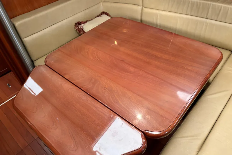 Tru Blu Yacht Photos Pics Wooden dining table in a 2010 Hunter 39 yacht interior with beige seating.