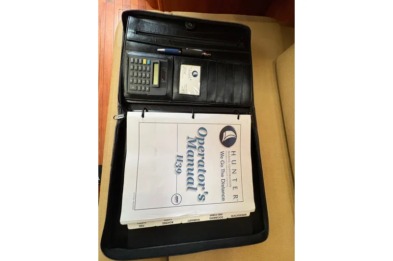 Tru Blu Yacht Photos Pics Hunter 39 Operator's Manual with calculator and pen in a black folder, 2010 model.