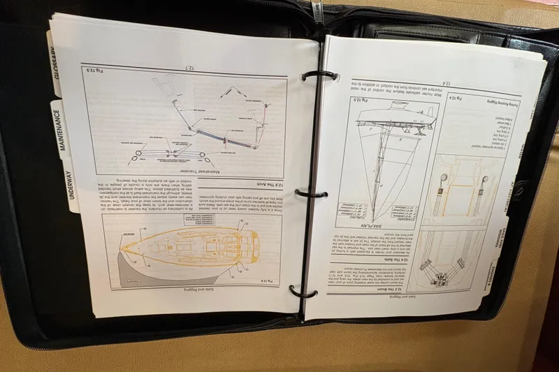 Tru Blu Yacht Photos Pics Open manual binder with diagrams and instructions for a 2010 Hunter 39 sailboat.