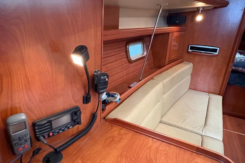 Tru Blu Yacht Photos Pics 2010 Hunter 39 yacht interior with beige seating, wood paneling, and communication equipment.