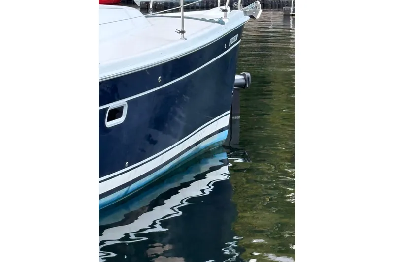 Tru Blu Yacht Photos Pics Hunter 39 sailboat from 2010 with blue hull, docked in calm water.