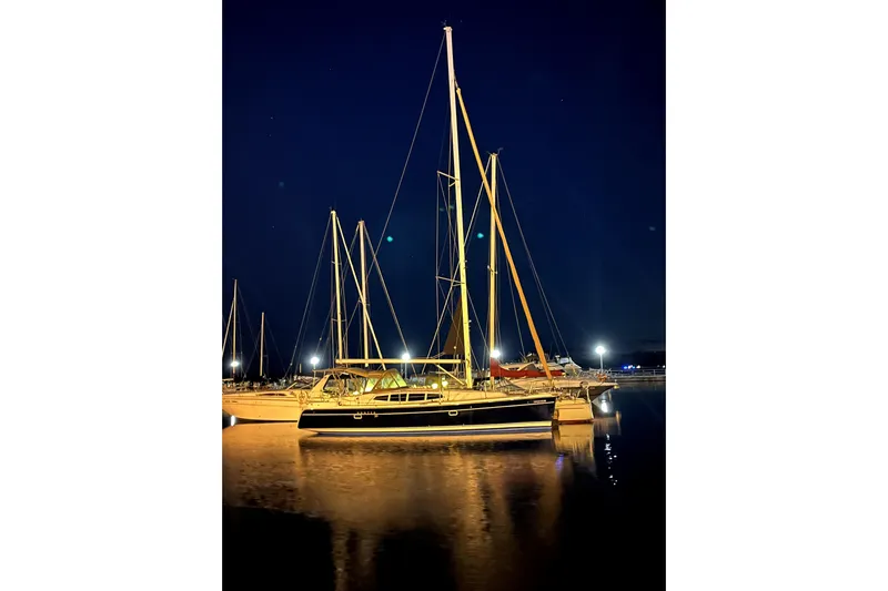 Tru Blu Yacht Photos Pics Sailboat Hunter 39, 2010 model, docked at night with reflections on water.