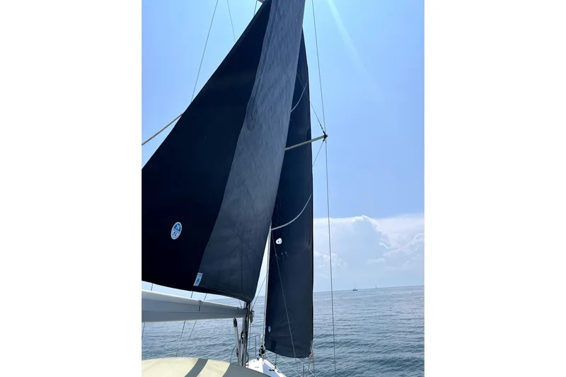 Tru Blu Yacht Photos Pics Sailing on a 2010 Hunter 39 yacht with black sails against a clear blue sky.