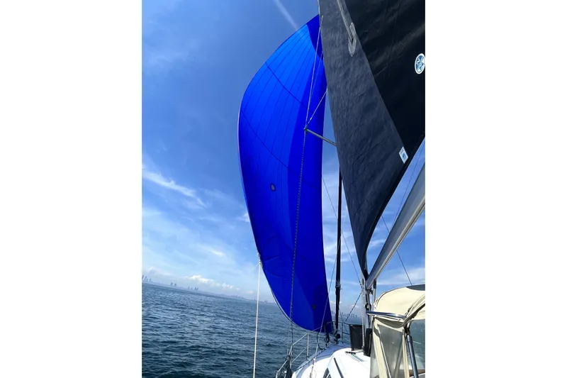 Tru Blu Yacht Photos Pics Sailing on a 2010 Hunter 39 with vibrant blue sails against a clear sky.