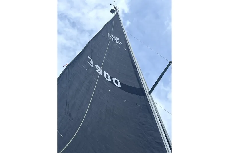 Tru Blu Yacht Photos Pics Sail of a 2010 Hunter 39 yacht against a cloudy sky.