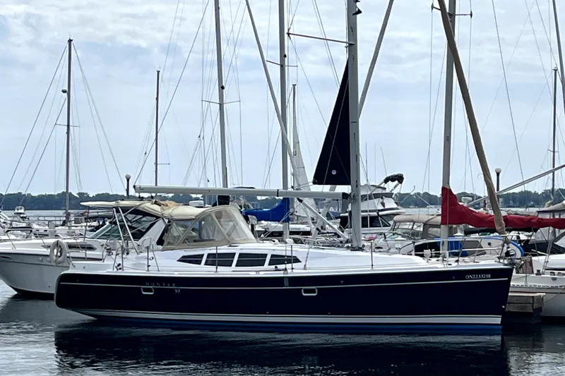 Tru Blu Yacht Photos Pics 2010 Hunter 39 sailboat docked at marina, surrounded by other boats.