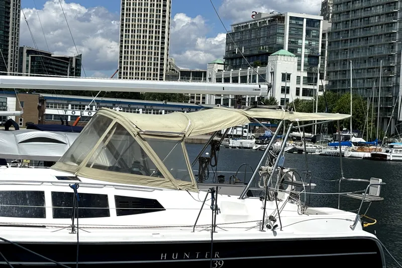Tru Blu Yacht Photos Pics Sailboat Hunter 39, 2010 model, docked in urban marina with cityscape background.