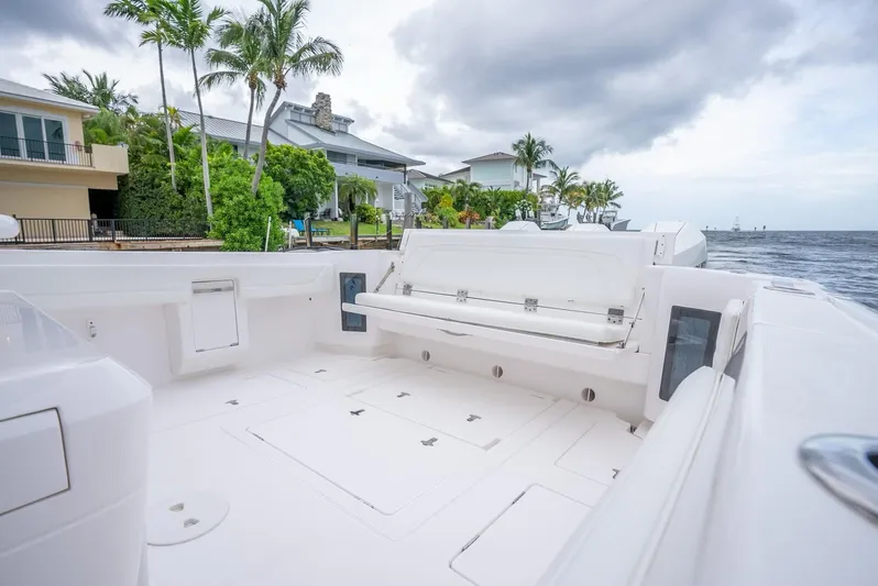  Yacht Photos Pics 2022 Intrepid 375 Nomad FE boat deck with seating, docked near waterfront homes.