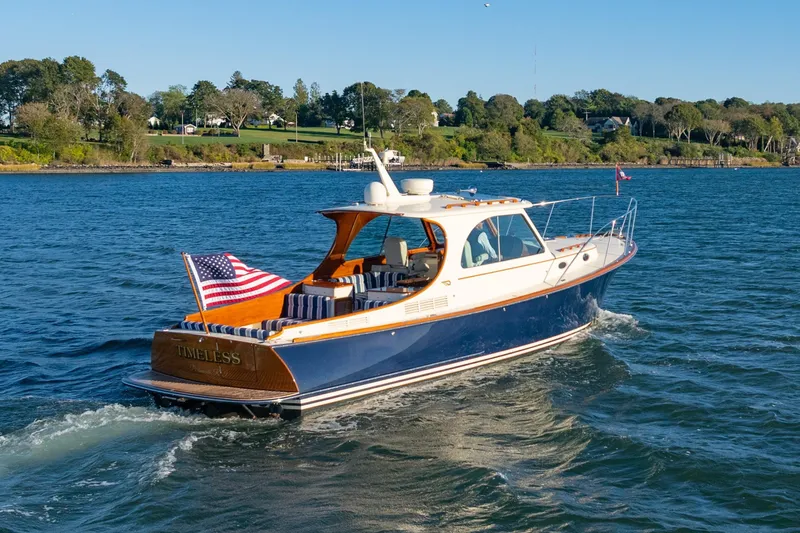 Timeless (name Reserved) Yacht Photos Pics 2015 Hinckley Picnic Boat MK III cruising on a scenic lake with American flag.