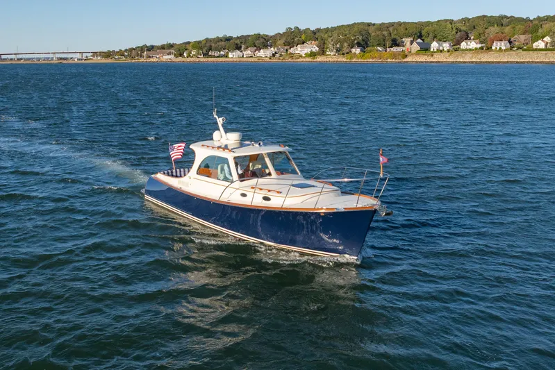 Timeless (name Reserved) Yacht Photos Pics 2015 Hinckley Picnic Boat MK III cruising on a scenic waterway with coastal backdrop.