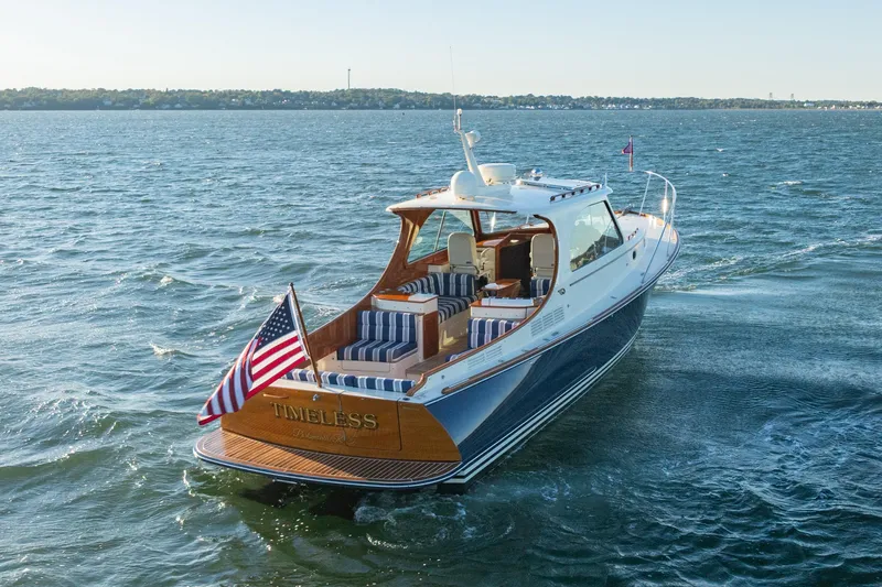 Timeless (name Reserved) Yacht Photos Pics 2015 Hinckley Picnic Boat MK III cruising on open water, featuring elegant design and American flag.