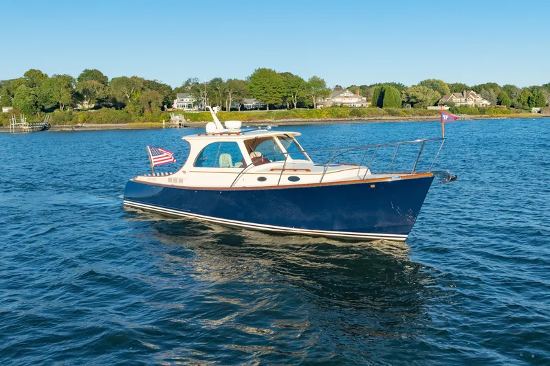 Timeless (name Reserved) Yacht Photos Pics 2015 Hinckley Picnic Boat MK III cruising on a scenic, calm blue waterway.