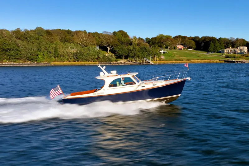 Timeless (name Reserved) Yacht Photos Pics 2015 Hinckley Picnic Boat MK III cruising on a scenic lake with lush green shoreline.