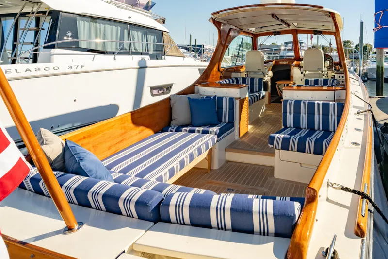 Timeless (name Reserved) Yacht Photos Pics 2015 Hinckley Picnic Boat MK III with striped seating, docked at marina.