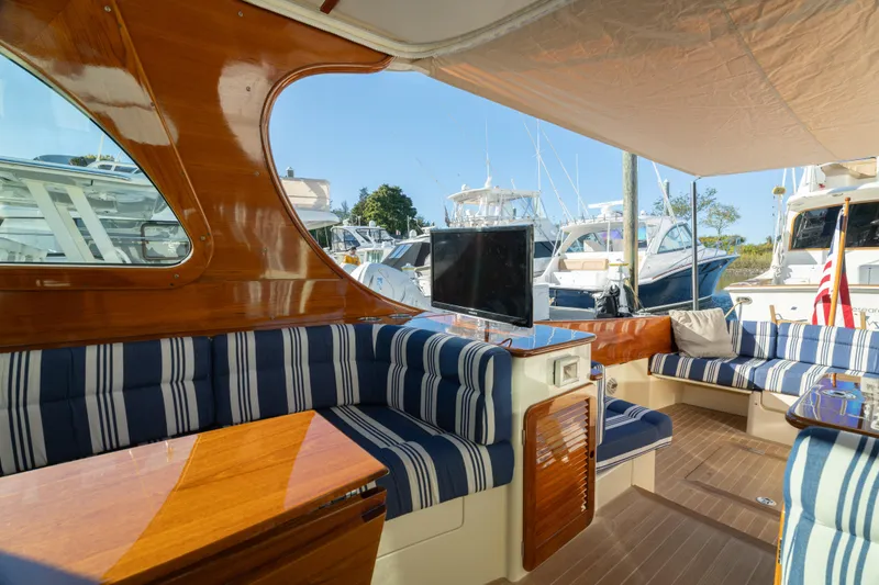 Timeless (name Reserved) Yacht Photos Pics Luxurious 2015 Hinckley Picnic Boat MK III interior with striped seating and polished wood finish.