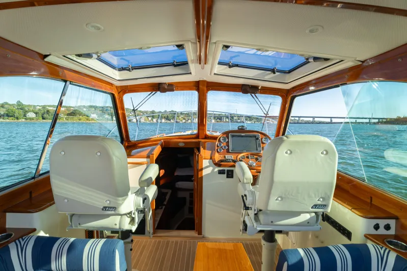 Timeless (name Reserved) Yacht Photos Pics Interior view of 2015 Hinckley Picnic Boat MK III, featuring helm and scenic waterway.