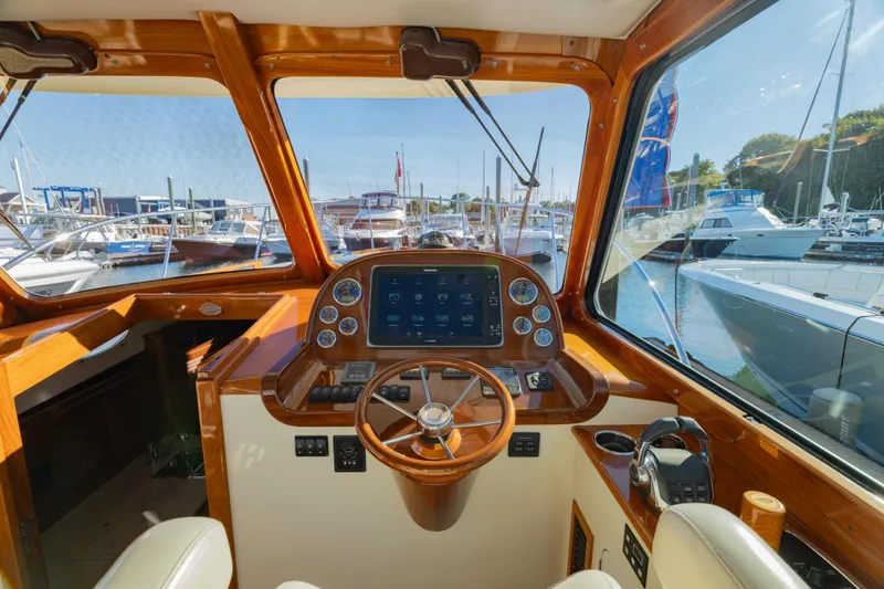 Timeless (name Reserved) Yacht Photos Pics Interior of 2015 Hinckley Picnic Boat MK III with wooden dashboard and marina view.