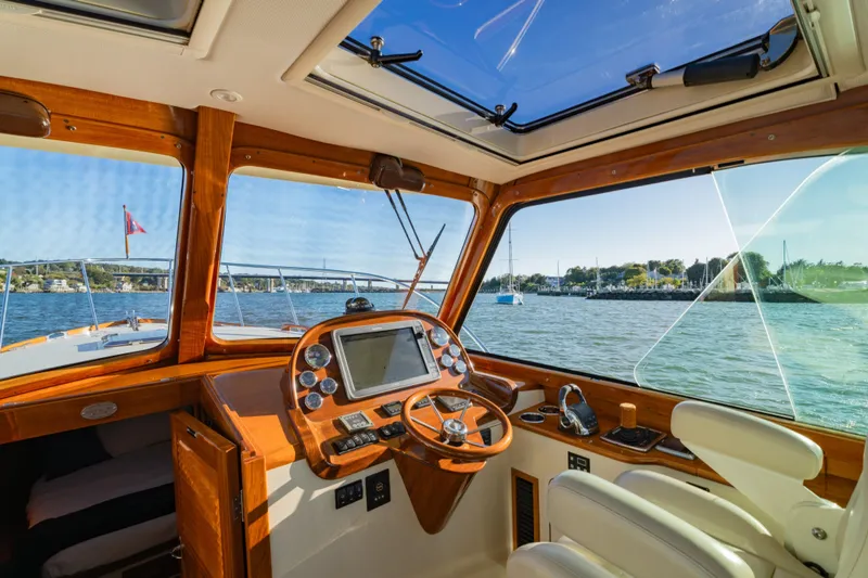 Timeless (name Reserved) Yacht Photos Pics Interior view of 2015 Hinckley Picnic Boat MK III, showcasing helm and scenic waterway.