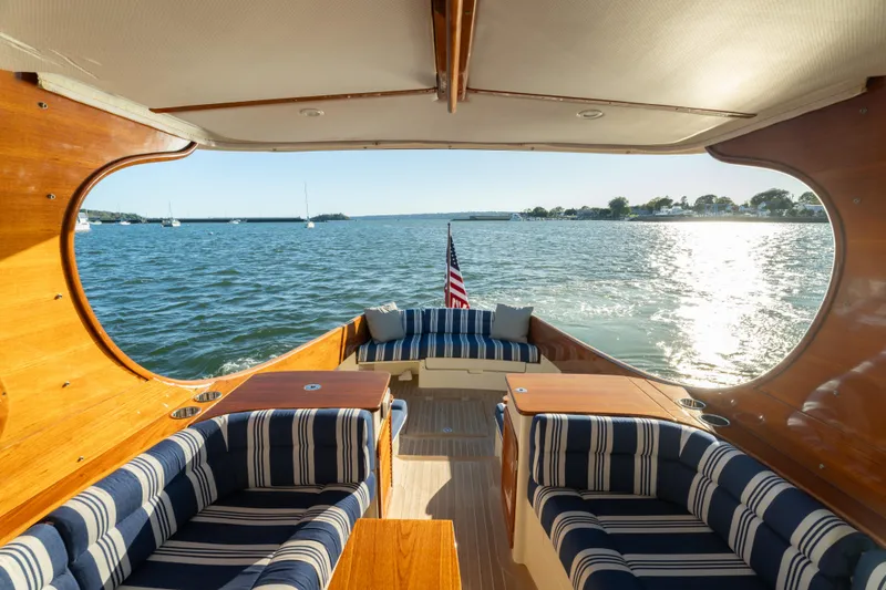 Timeless (name Reserved) Yacht Photos Pics 2015 Hinckley Picnic Boat MK III interior with striped seating, overlooking serene waters.