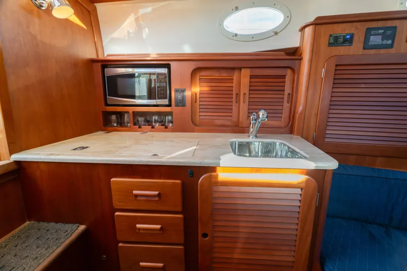 Timeless (name Reserved) Yacht Photos Pics 2015 Hinckley Picnic Boat MK III interior with wooden cabinetry, sink, and microwave.