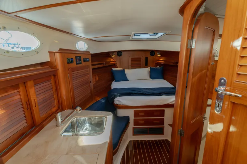 Timeless (name Reserved) Yacht Photos Pics Luxurious 2015 Hinckley Picnic Boat MK III cabin interior with wood finish and cozy bed.