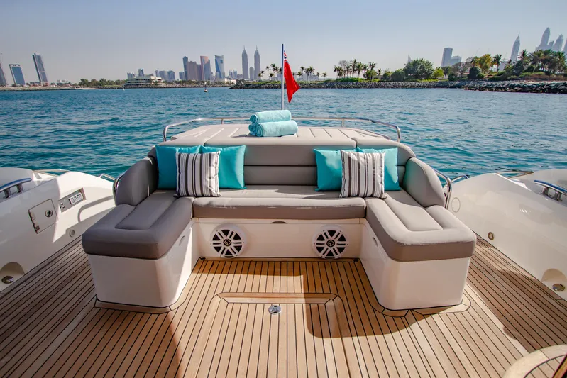 Outlaw Yacht Photos Pics Luxurious Sunseeker Manhattan 55 yacht deck with plush seating, overlooking a scenic waterfront.