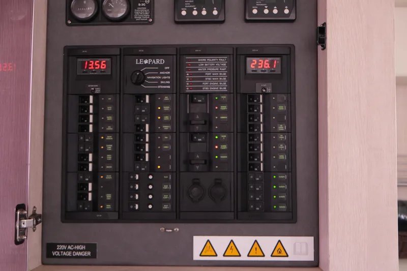Jolly Dacha Yacht Photos Pics Electrical control panel of a 2015 Leopard 48 yacht, displaying voltage readings and warning signs.