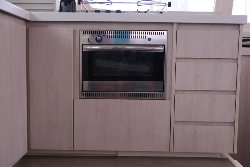 Jolly Dacha Yacht Photos Pics Modern kitchen with built-in stainless steel oven, light wood cabinetry, Leopard 48, 2015 model.