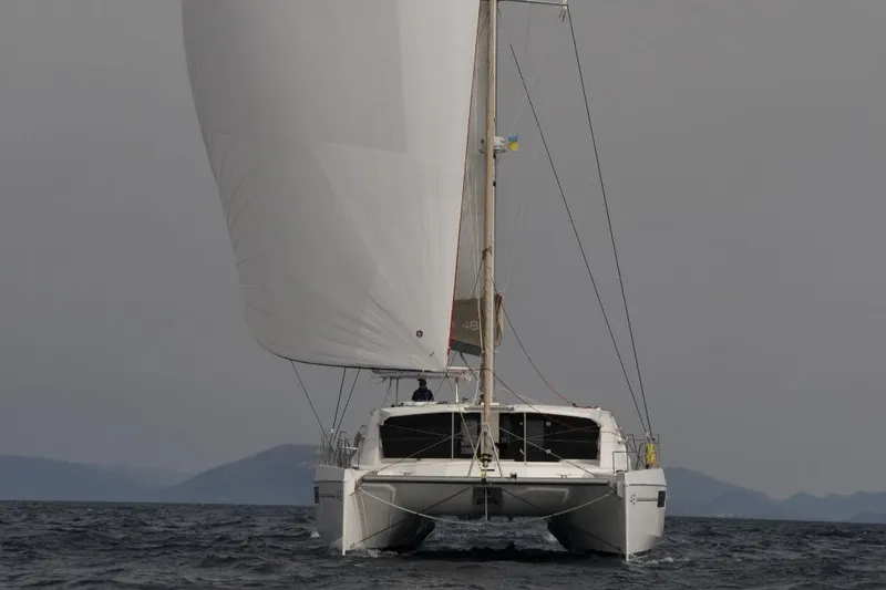 Jolly Dacha Yacht Photos Pics Front view of a 2015 Leopard 48 catamaran sailing on open water.