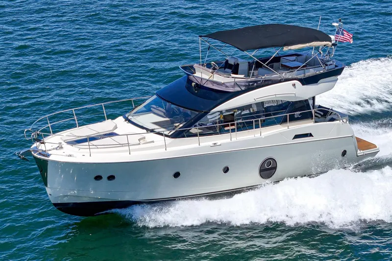 The Riviera Yacht Photos Pics 2017 Monte Carlo MC5S yacht cruising on open water with American flag.