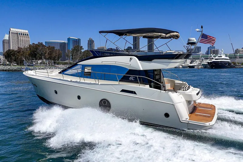 The Riviera Yacht Photos Pics 2017 Monte Carlo MC5S yacht cruising near city skyline on a sunny day.