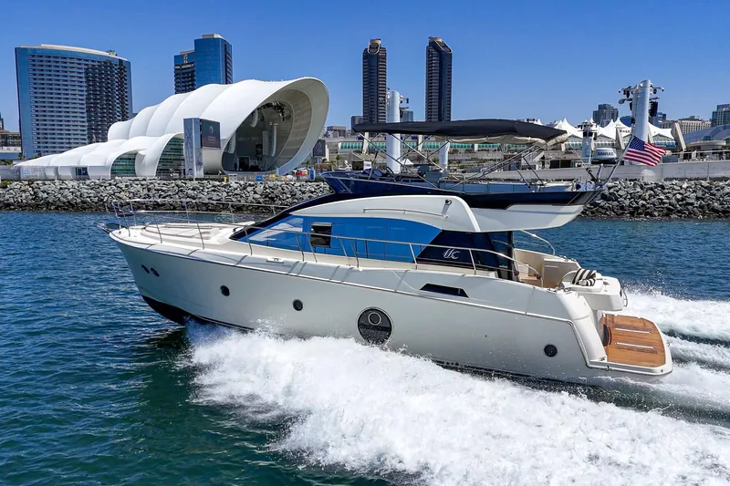 The Riviera Yacht Photos Pics 2017 Monte Carlo MC5S yacht cruising near modern city skyline and waterfront architecture.